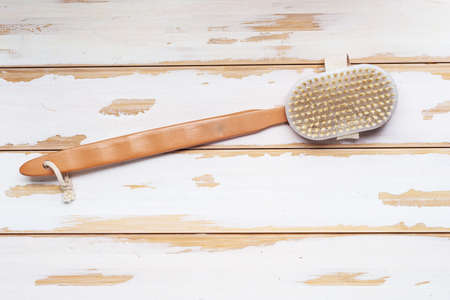 Natural shower brush with wooden handle on white boards. view from above. Space for text.の写真素材