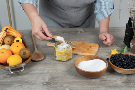 woman's hands canning lemon. pour sugar into jar of lemon.の写真素材