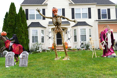 Decoration of the facade of the house for the holiday of Halloween. Pumpkin skeletons and terrible monsters on the lawn.の写真素材
