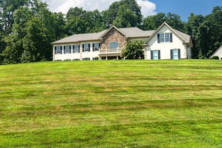Leesburg. Virginia. USA. August 15, 2022. Large country house and summer landscape with a perfect lawn. Blue sky and white clouds.のeditorial素材