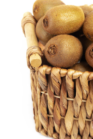 Harvest kiwi in a wicker basket on white background. close-up. Space for text.の写真素材