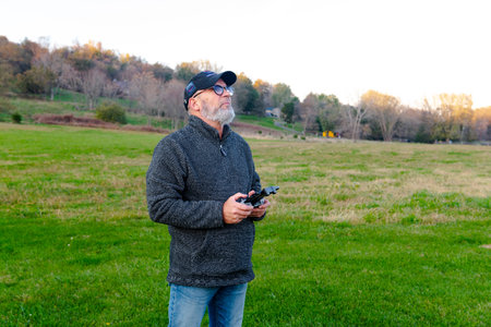 an adult man with a beard launches a drone into the sky. Holds the remote control and watches the...