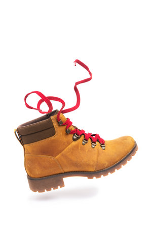 durable leather walking boot on white background isolated. Stylish sporty dynamic accessory for adventures. Classic walking shoes with red laces on the move or on the move.の写真素材