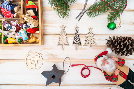 Christmas composition of New Year's toys, fir branches and Santa Claus on a light table. view from...