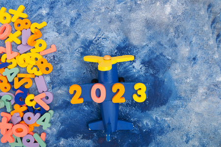 Airplane with numbers 2023. The numbers was selected from a bunch of unnecessary numbers. Preparing...