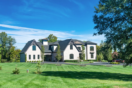 Large modern luxury single-family country home with a large mowed lawn.のeditorial素材