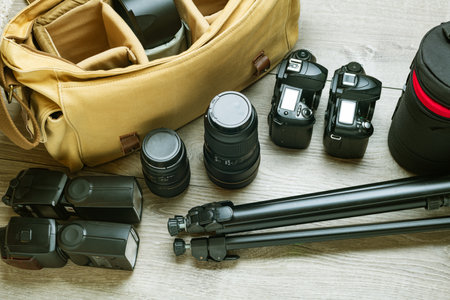 Flashes, cameras, lenses, tripod and photographer's bag are ready to be packed.
