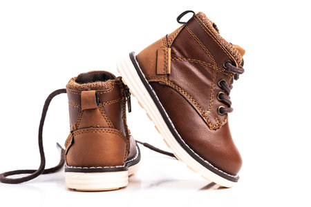 Brown children's shoes made of leather for a boy on a white background. close-up.