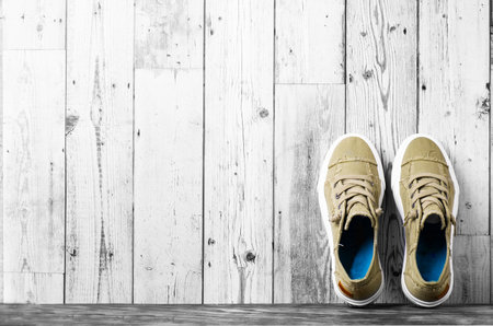 retro hipster sneakers with white laces stand against a gray wall on the floor. Banner. Space for text.の写真素材