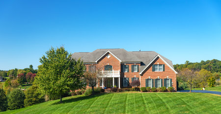 Large brick house with a large green lawn.のeditorial素材