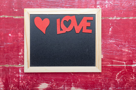 photo Frame, heart and word LOVE for Valentine's Day on a red wooden table. top view with copy spaceの写真素材