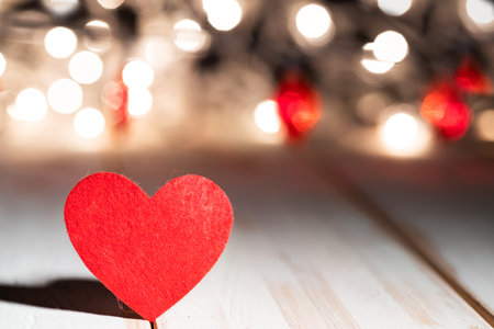 red heart on wooden table against defocused bokeh light background. Love, valentine's day concept.の写真素材