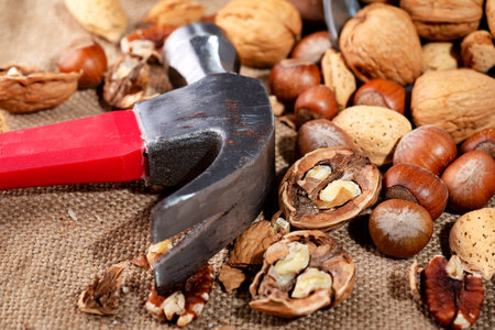 Various nuts and hammers on burlap. close-up.