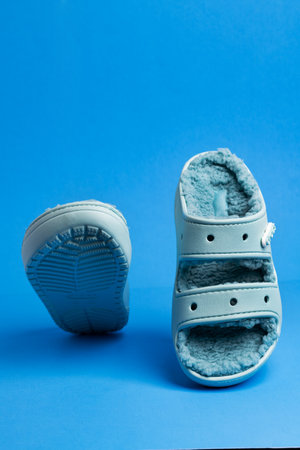 Blue bright trendy beach shoes Crocs on a blue background. Summer beach shoes for vacation.Space for text.のeditorial素材