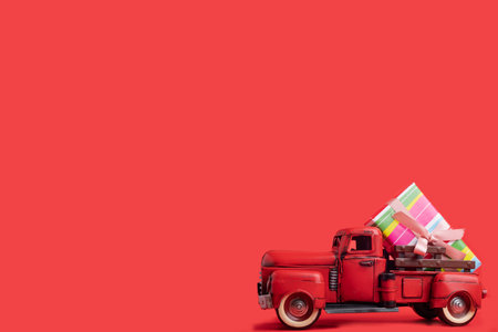 red tractor carries boxes with gifts on a red background. Banner, space for text.