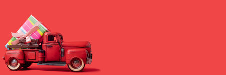 red tractor carries boxes with gifts on a red background. Banner, space for text.の写真素材