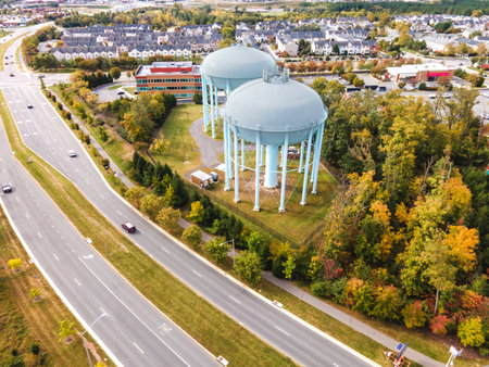 water tower near the road in a small town in the USA. drone view. Autumn Forest, road, low-rise buildings.の写真素材