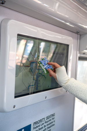 woman holds a SmarTrip subway map and studies the subway map while on a Metrorail train.
