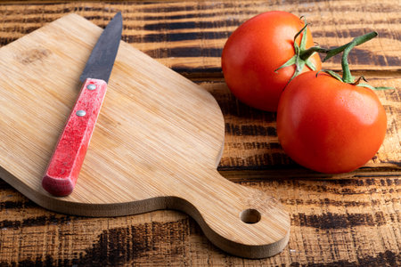 fresh, ripe tomato and a knife on a cutting board.の写真素材