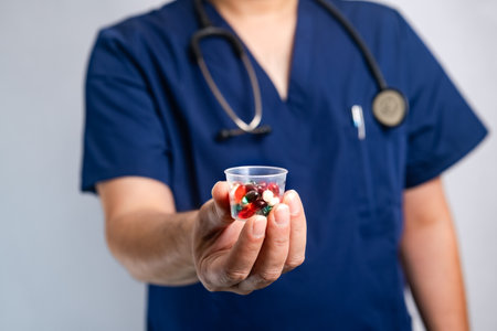 doctor holds in his hands different pills in a glass and offers them to the patient in the clinic. close-upの写真素材