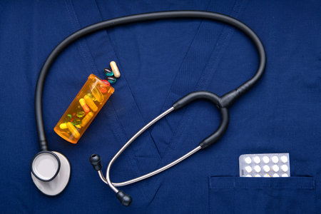 stethoscope with drugs is lying on a blue medical gown. view from above. Space for text.の写真素材