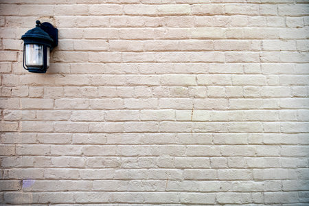 Brick-painted wall with a lantern. Background of a plain, painted, brick wall.