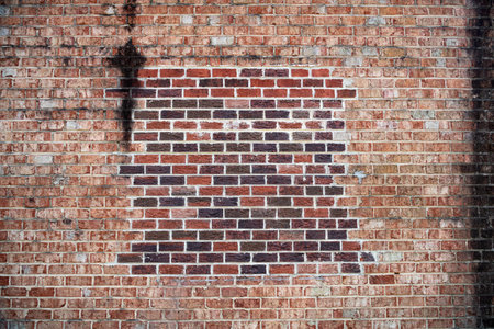 brick wall, old red brick background with new brick patch.の写真素材