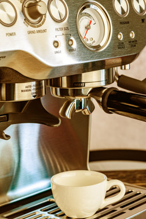 Close-up of a modern steel coffee machine with control buttons and a barometer.の写真素材