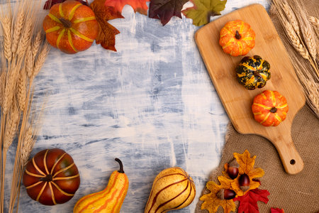 autumn composition. Pattern of autumn leaves, pumpkins and wheat on the table. Flat lay, top view.の写真素材