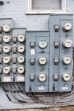 group of electric meters of an apartment building hang on a brick wall. Close-up.のeditorial素材