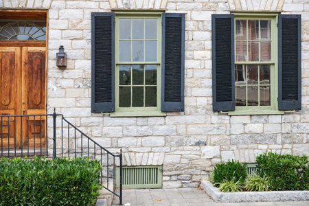 Two windows and a door in the stone wall of the house.