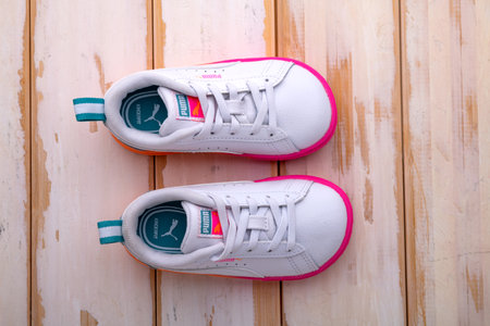 Children's Puma sneakers on a white floor. View from above. Sports concept.のeditorial素材