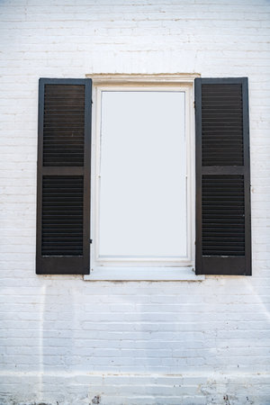 window with open shutters in a white brick wall with space for text.の写真素材
