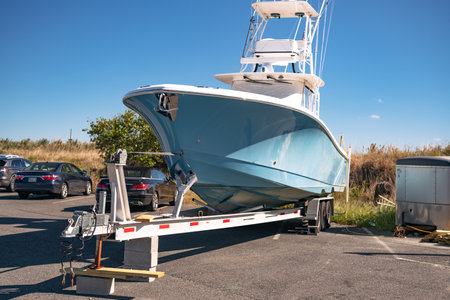 large motorboat on a car trailer is parked at the pier.
