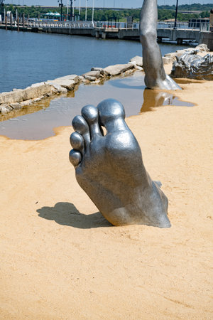 large metal leg is buried in the sand on the beach.のeditorial素材
