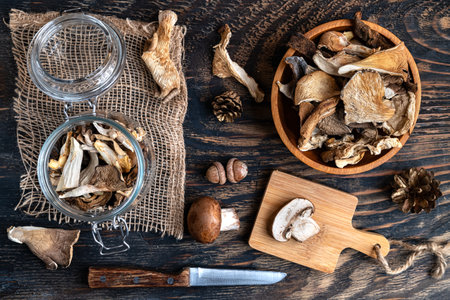 Various dried mushrooms in a wooden bowl and on a cutting board. View from above.の写真素材