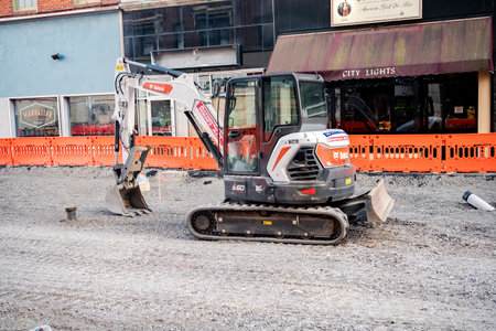 small excavator on a gravel road during street repair work in an urban environment