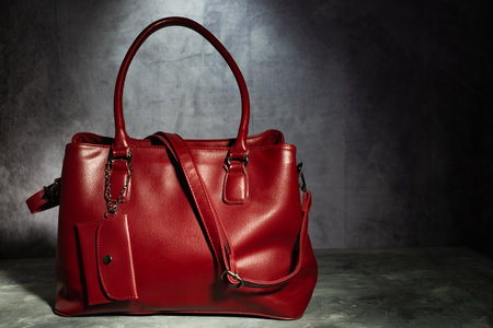 Fashionable, red, leather, women's bag against a gray wall. Close-up.の写真素材