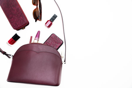 Stylish women's bag on a white background. Fashionable accessory made of burgundy leather.の写真素材
