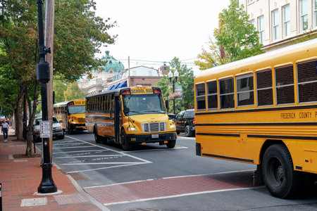 School buses cross an intersection in the center of a small town.