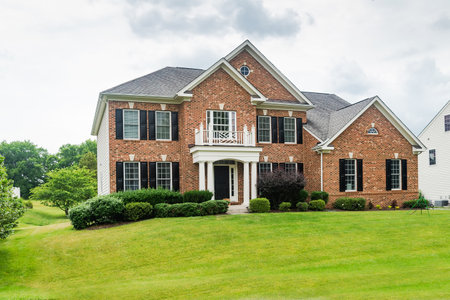 Large brick House in American suburb. Beautiful house with green lawn.のeditorial素材