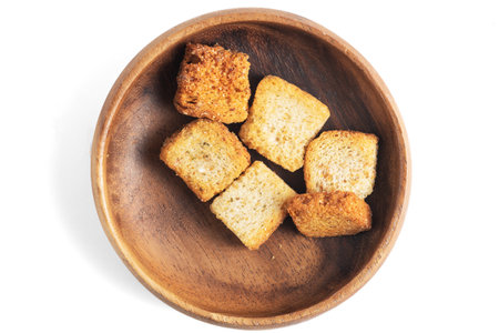 delicious crispy fried croutons in wooden bowl isolated on whiteの写真素材