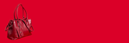 Red women's leather bag on a red background. Bannerの写真素材