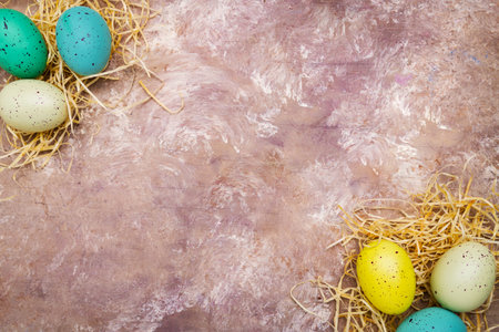 Easter-colored eggs lie on straw. View from above. Space for textの写真素材