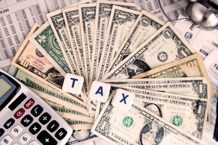 Time to pay taxes. Word TAXES on the background of banknotes and tax forms and tables.の写真素材