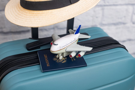 A hat with a US passport lies on a suitcase with a US flag. Travel concept.