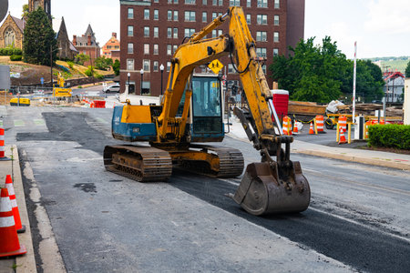 yellow excavator in the center of a historic town in Maryland. Restoration work in the city.