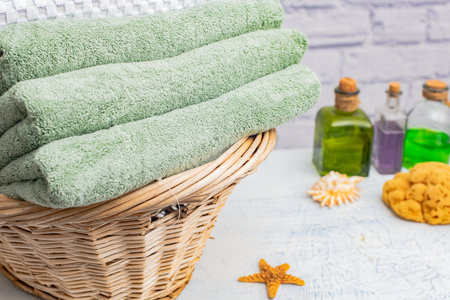 stack of terry bath towels in a wicker basket on a table.の写真素材