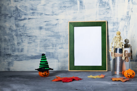 Photo frame surrounded by Halloween decorations, skeletons and colorful hats with pumpkinsの写真素材