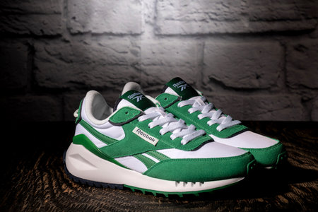 Reebok green sneakers on a dark wooden table.のeditorial素材